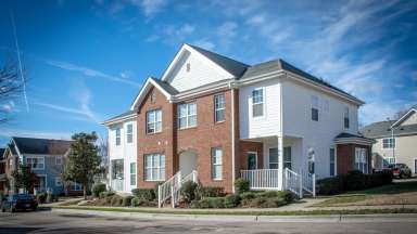 Apartment building with brick and white vinyl siding exterior