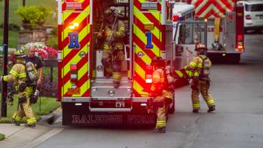 Firefighters disembarking from back of fire engine