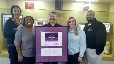 group of emergency communications staff holding accreditation certificate. 