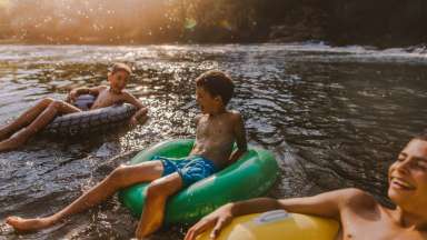 Three kids in tubes on the river