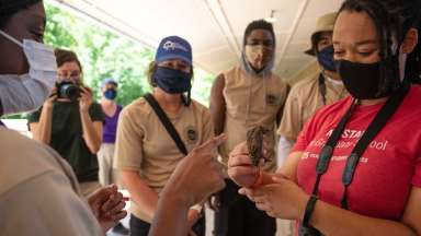 Nature instructor holding bird to show students