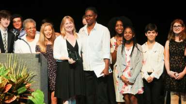 Volunteer award recipients lined up on stage at ceremony