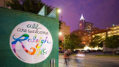 All Are Welcome Raleigh Mural at night