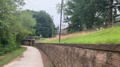 A greenway trail near Crabtree Creek with longer grass along the creek.