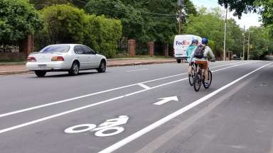 Two bikes traveling in the bike lane on Person Street near Governor's Manson, heading north