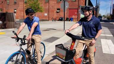 Council member and interviewer sitting on road bikes