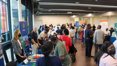 Attendees walk around to tables at Affordable Housing Open House event.