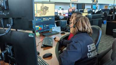 Two emergency communications employees looking at a monitor