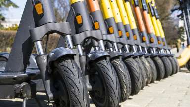 Electric scooters lined up on sidewalk