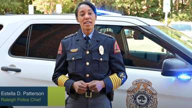 Raleigh Police Chief Patterson standing in front of police car