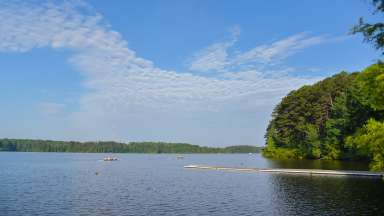 image of blue clouds, trees and a lake