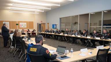 Members of Raleigh Police Departement sitting in a large room listening to a speaker