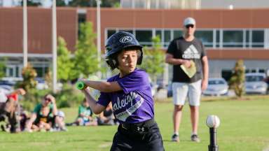 a child swinging a bat at a t-ball T