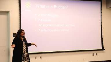 Budget Department Director standing in front of a What is a Budget slide