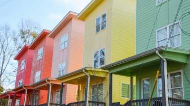 houses in a row painted different rainbow colors