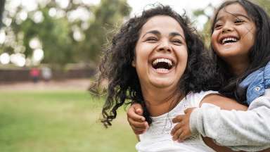 a person smiling with a child on their back