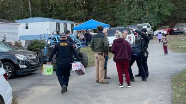 Raleigh police officers help carry supplies in a community in Black Mountain