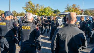 Raleigh police officers stand in a circle during a briefing before heading to western NC to help with recovery efforts.