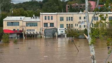 Flooded business district with several store front businesses damaged by water after a hurricane.