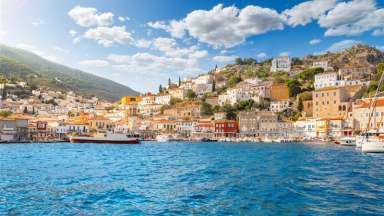 small harbor with boats and village with shops and cafes on the Greek island of Hydra, one of the Saronic islands off of mainland Greece