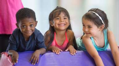 three toddlers playing and smiling