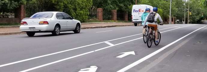 Two bikes traveling in the bike lane on Person Street near Governor's Manson, heading north