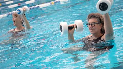 Two adult women participating in an aerobic exercise water class