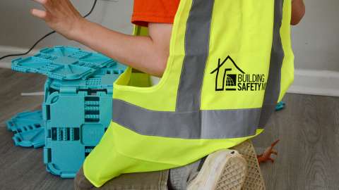 Person in reflective vest playing with toys