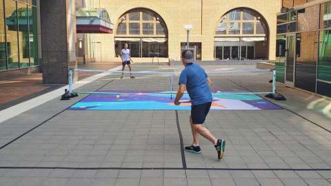 Two people play pickleball.