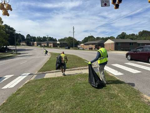 Workforce members clean a roadway