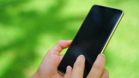 a person holding a phone while outdoors