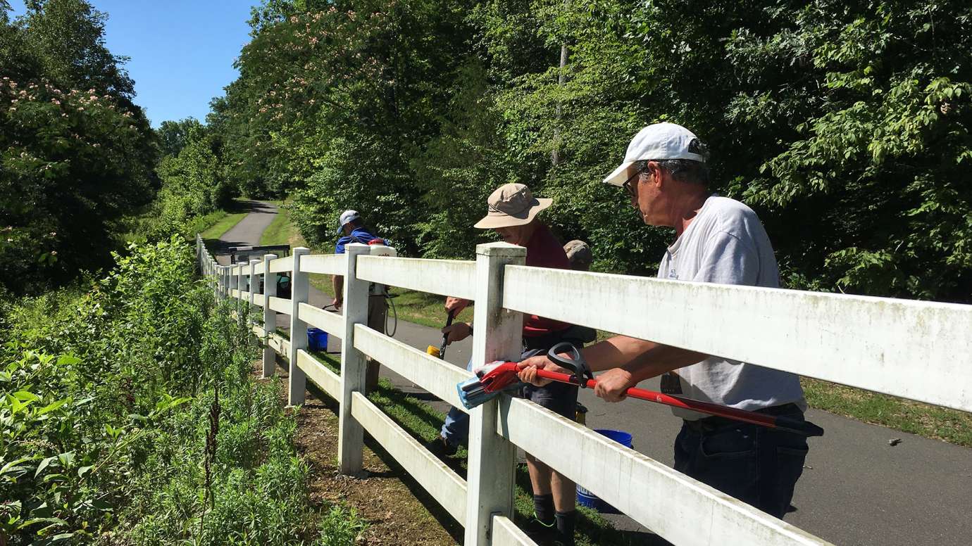 Volunteer painting a fence