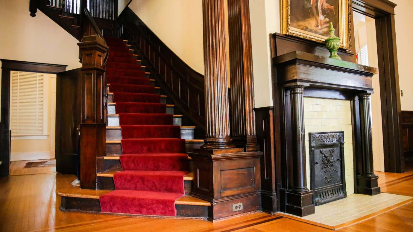 The staircase and a fireplace inside the Tucker House