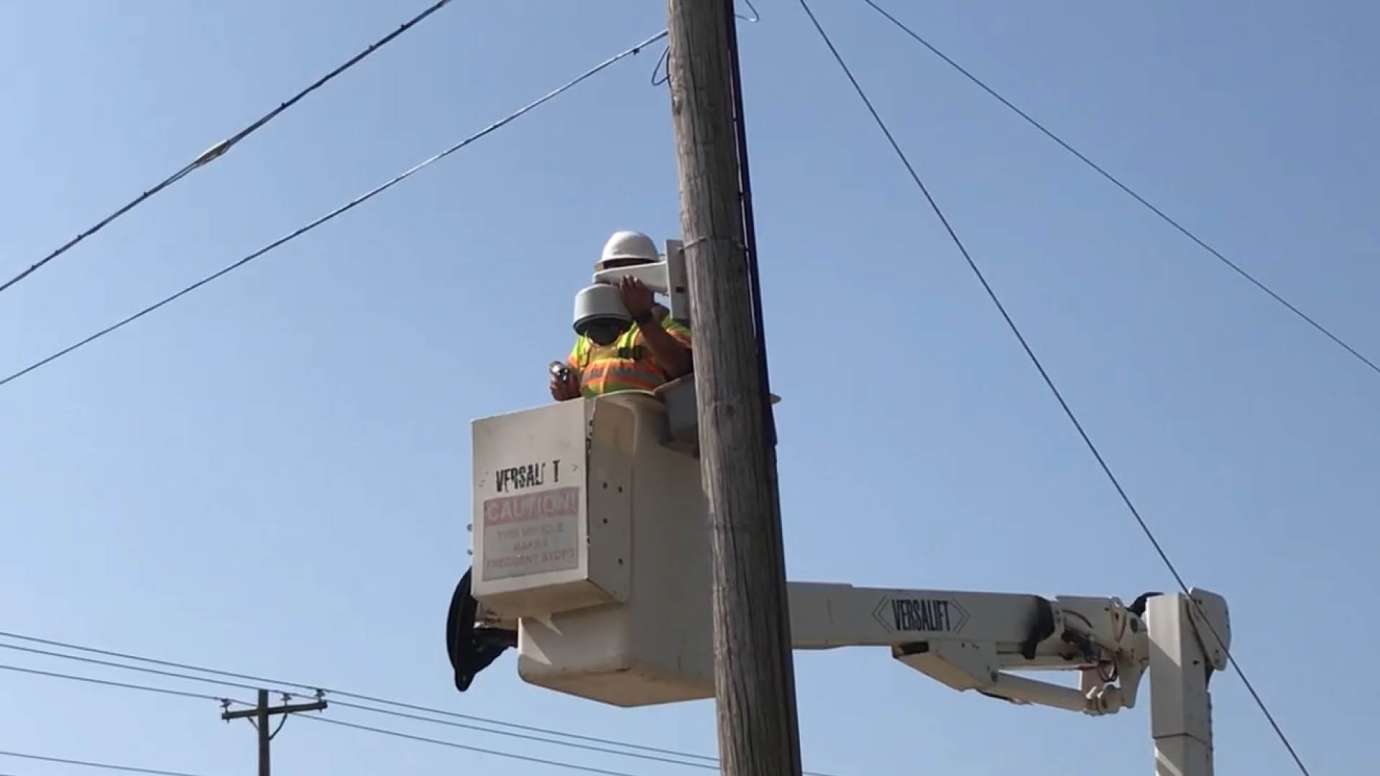 A construction worker installing a camera to monitor flooding