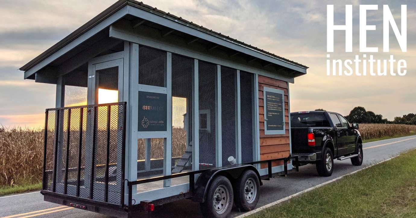 chicken coop trailer being towed by a black truck