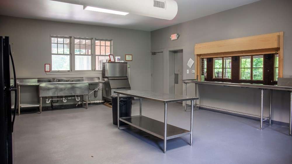 Interior view of kitchen with large counter tops, sink, and windows