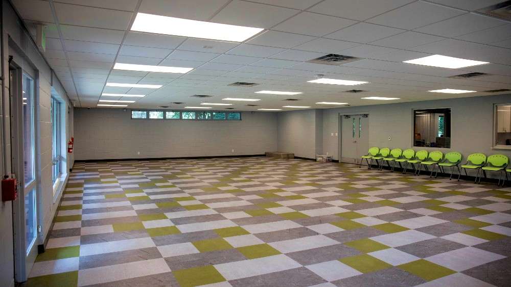 Large interior room with tile floor and chairs lined against the wall