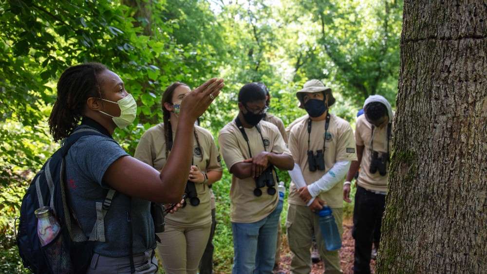 Birder points to tree showing youth in nature