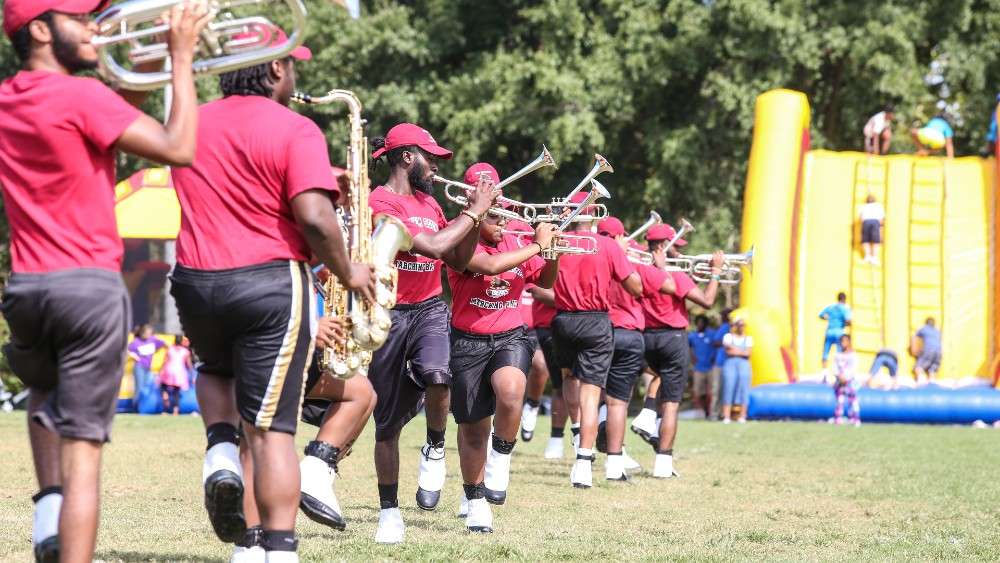 Band playing music in field with bouncy house in the background