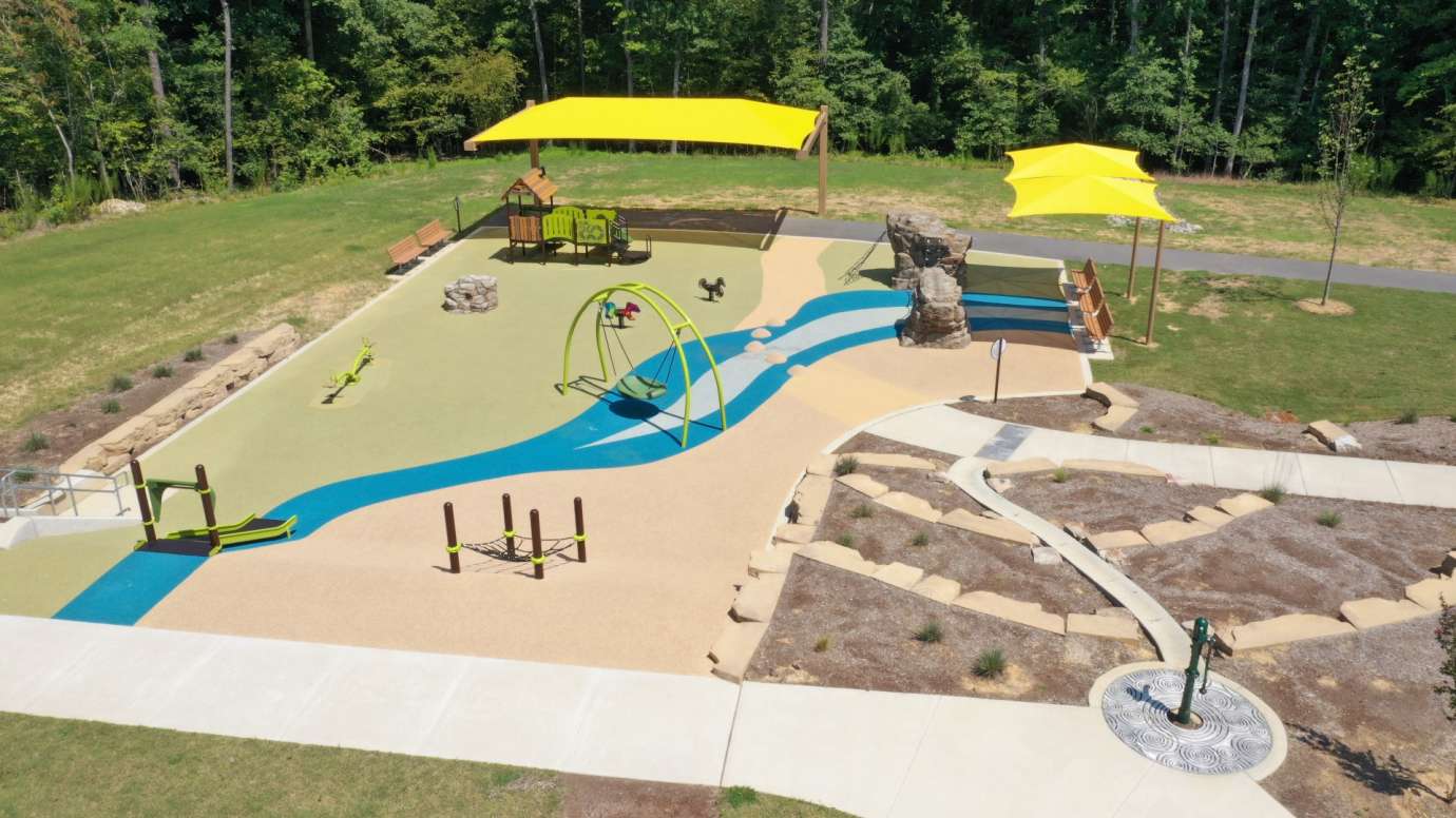 Aerial shot of the River Bend Park playground with yellow shades and rubber surface and play structures