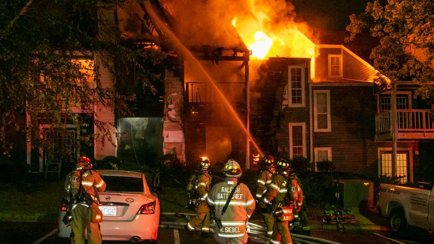 Firefighters spraying water on house fire