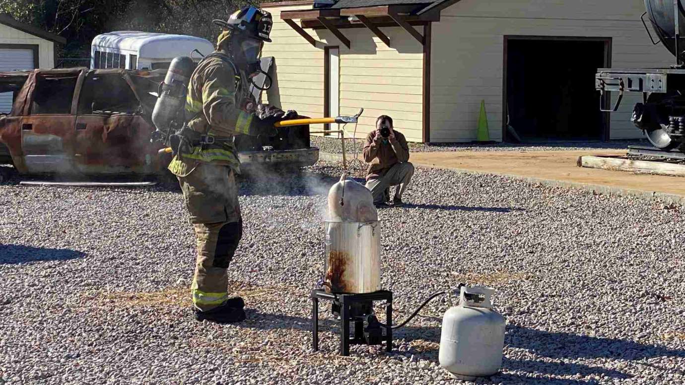 Fireman placing turkey in fryer