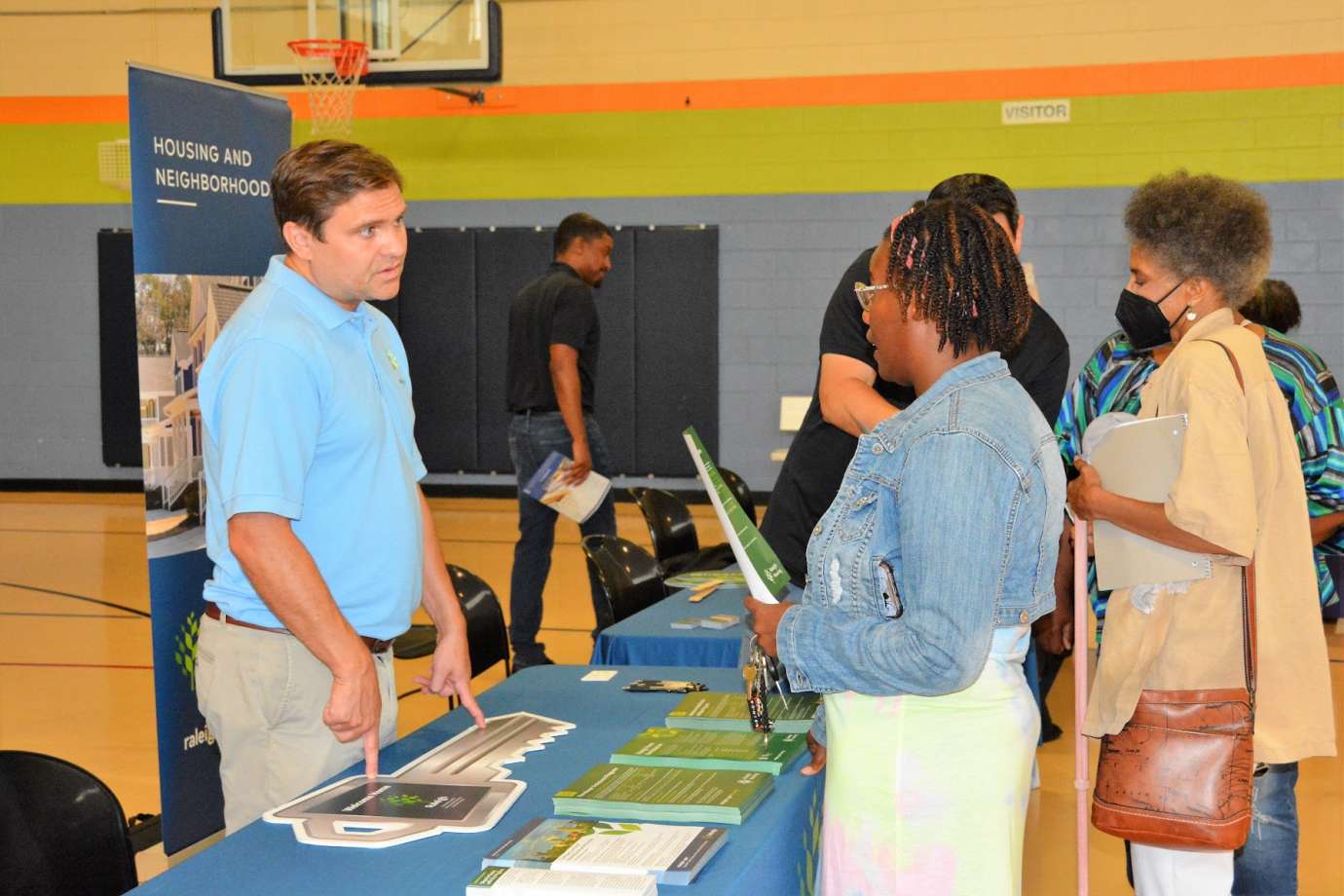 Photo of event attendees talking with representative from City of Raleigh