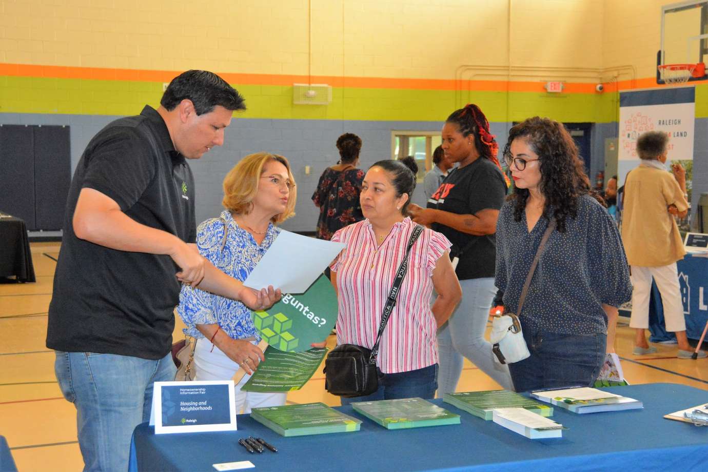 Photo of event attendees talking with representative from City of Raleigh