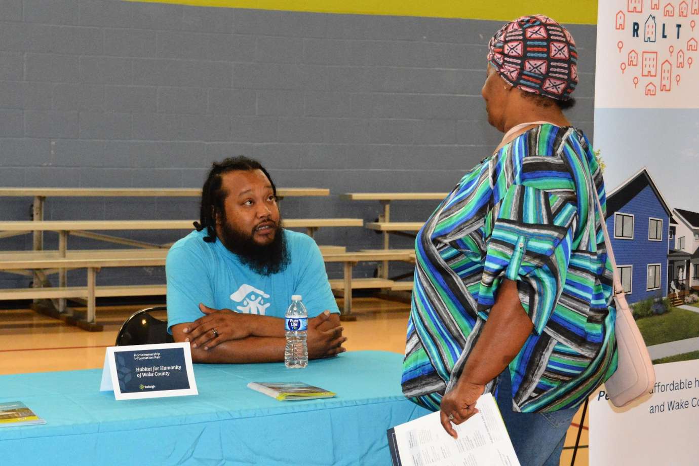 Photo of event attendees talking with representative from Habitat Wake