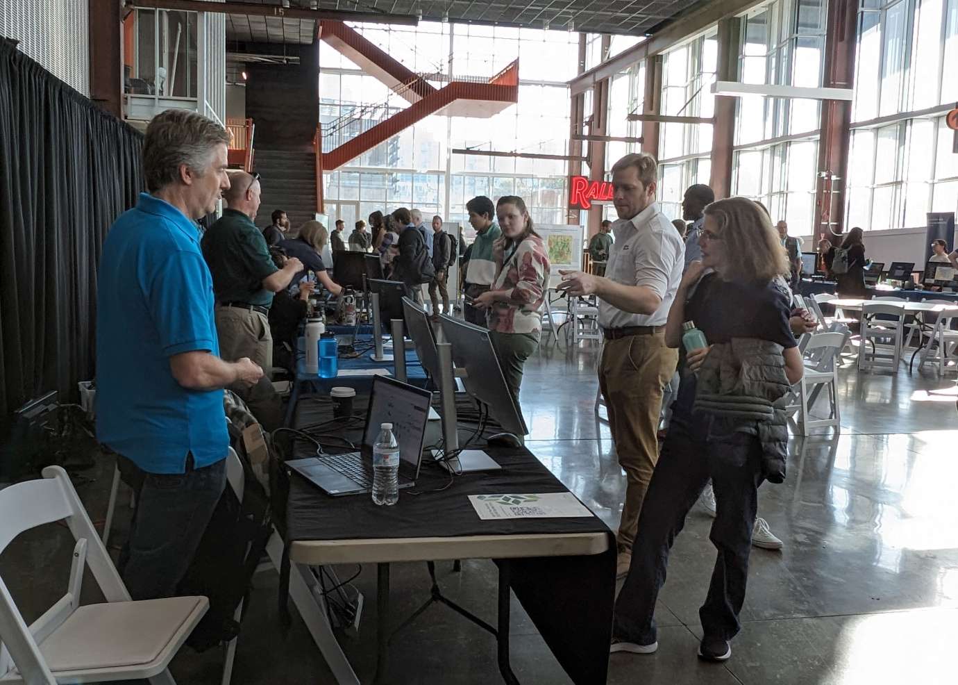 GIS Day attendees at Raleigh Union Station talk with table participant