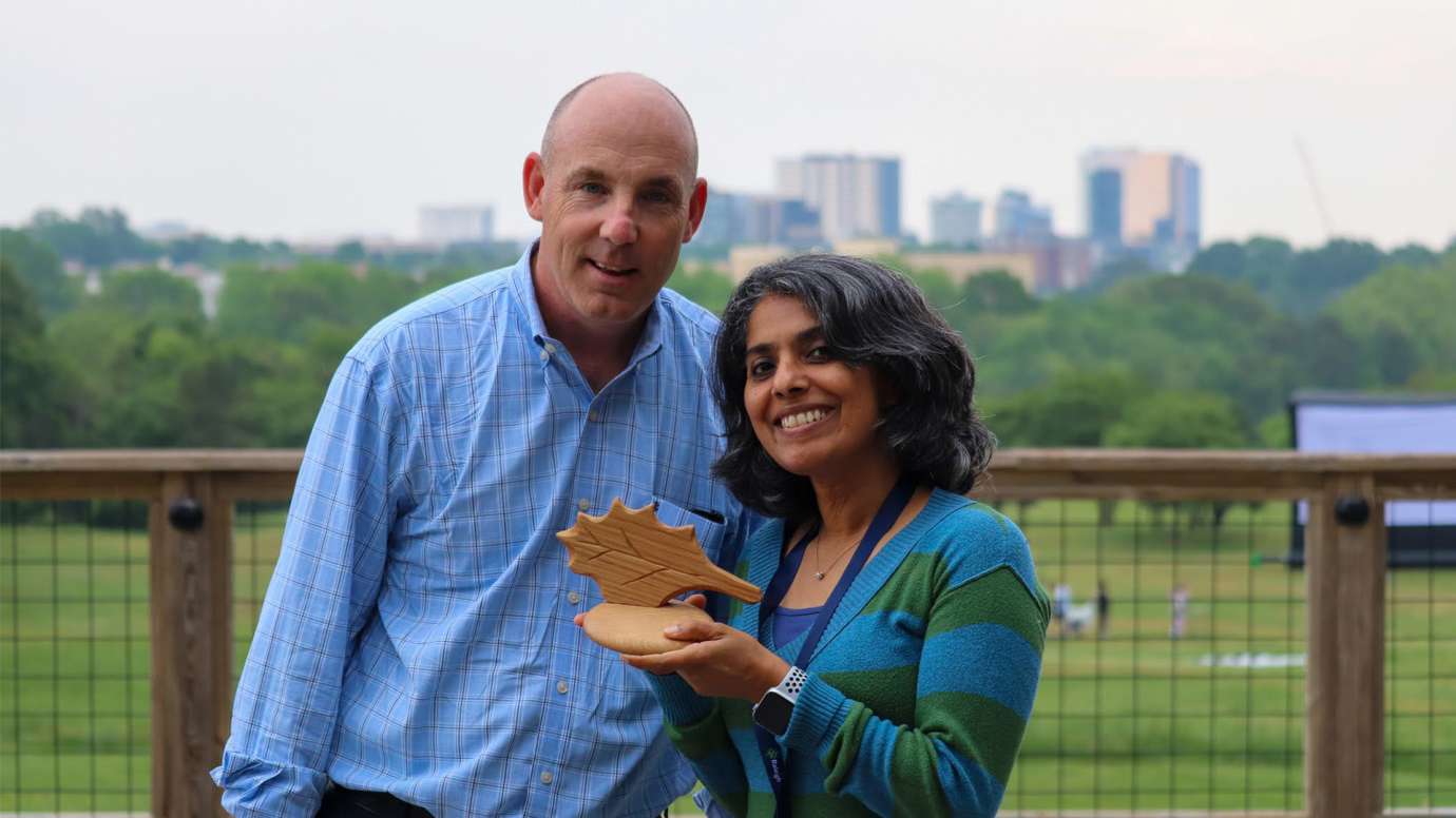 Two members of IT department pose with award