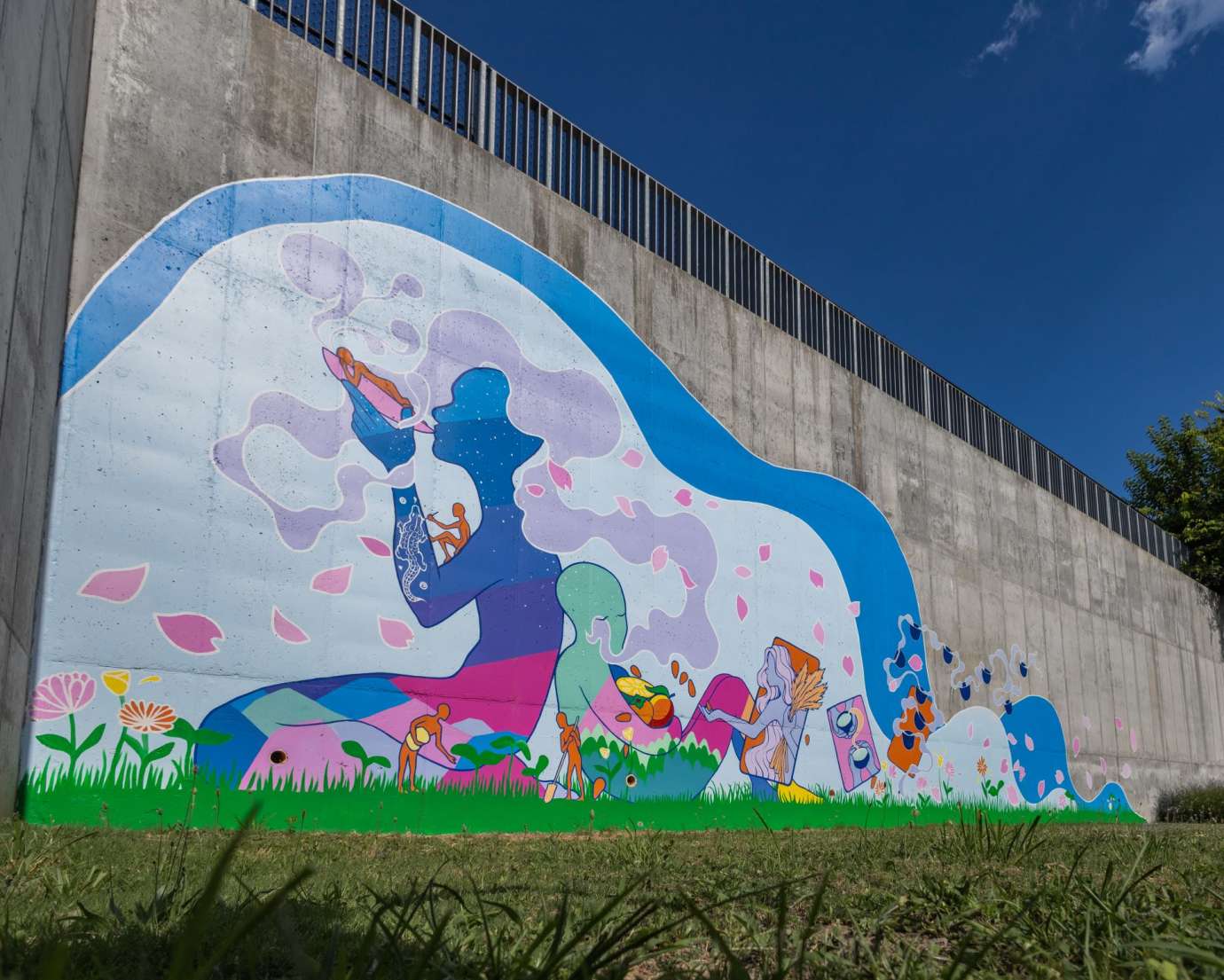 Colorful mural on a cement wall featuring an undulating wave figure