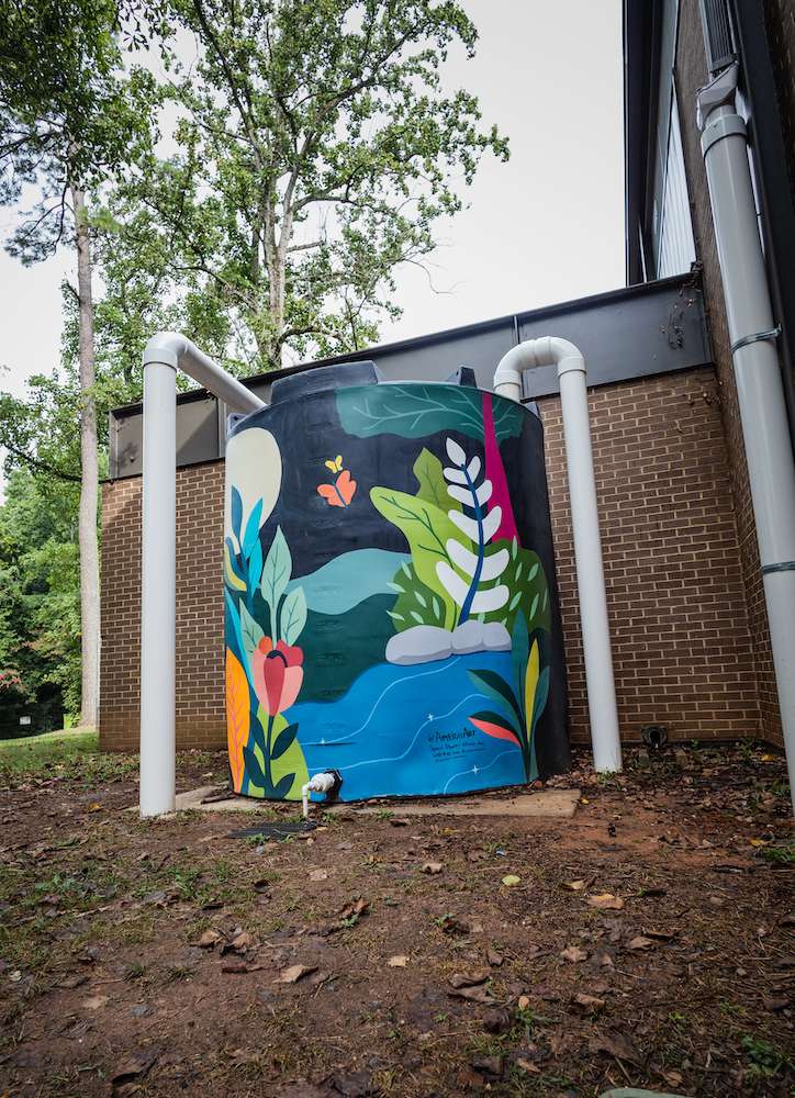 A water cistern painted with brightly colored plants.