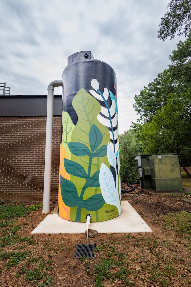 A vertical cistern painted with brightly colored plants.